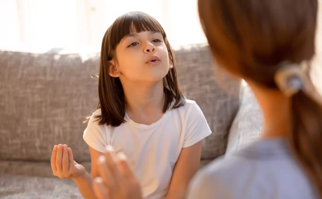 Child on couch with therapist in bright room
